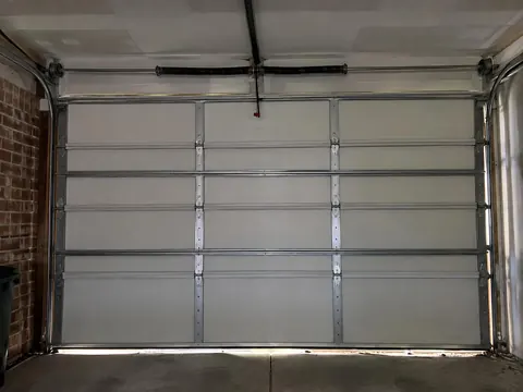 Inside view of a garage door with its torsion spring mounted above