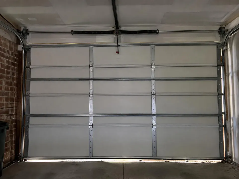 Inside view of a garage door with its torsion spring mounted above