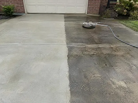 Concrete driveway half pressure-washed, showing clean and dirty sections